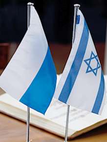 Die Flagge des Freistaats Bayern (links) und die Flagge des Staates Israel (rechts) auf einen Tisch.