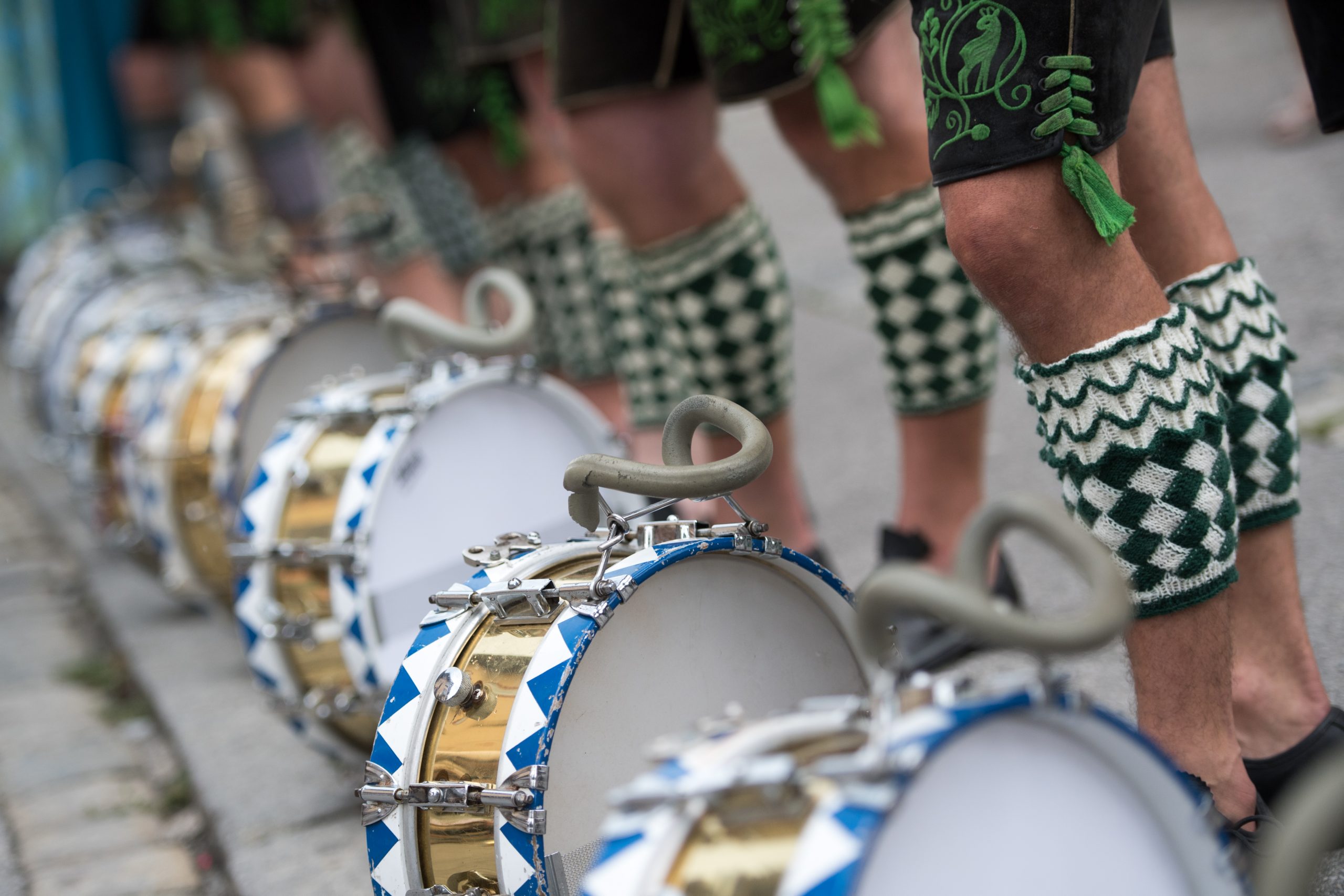 Mitglieder der Oberländer Trachtenvereinigung in bayerischer Tracht stehen hinter ihren Trommeln.