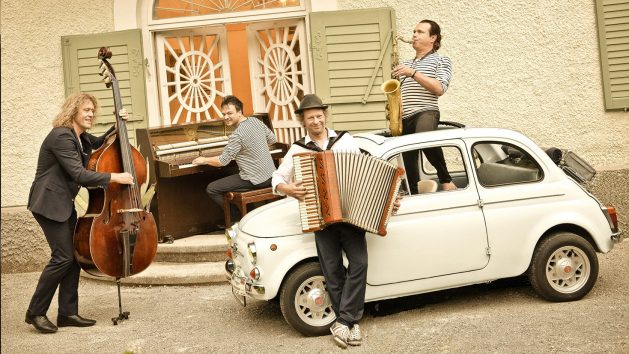 Die Band Quadro Nuevo mit ihren Instrumenten neben einem Auto. © Quadro Nuevo