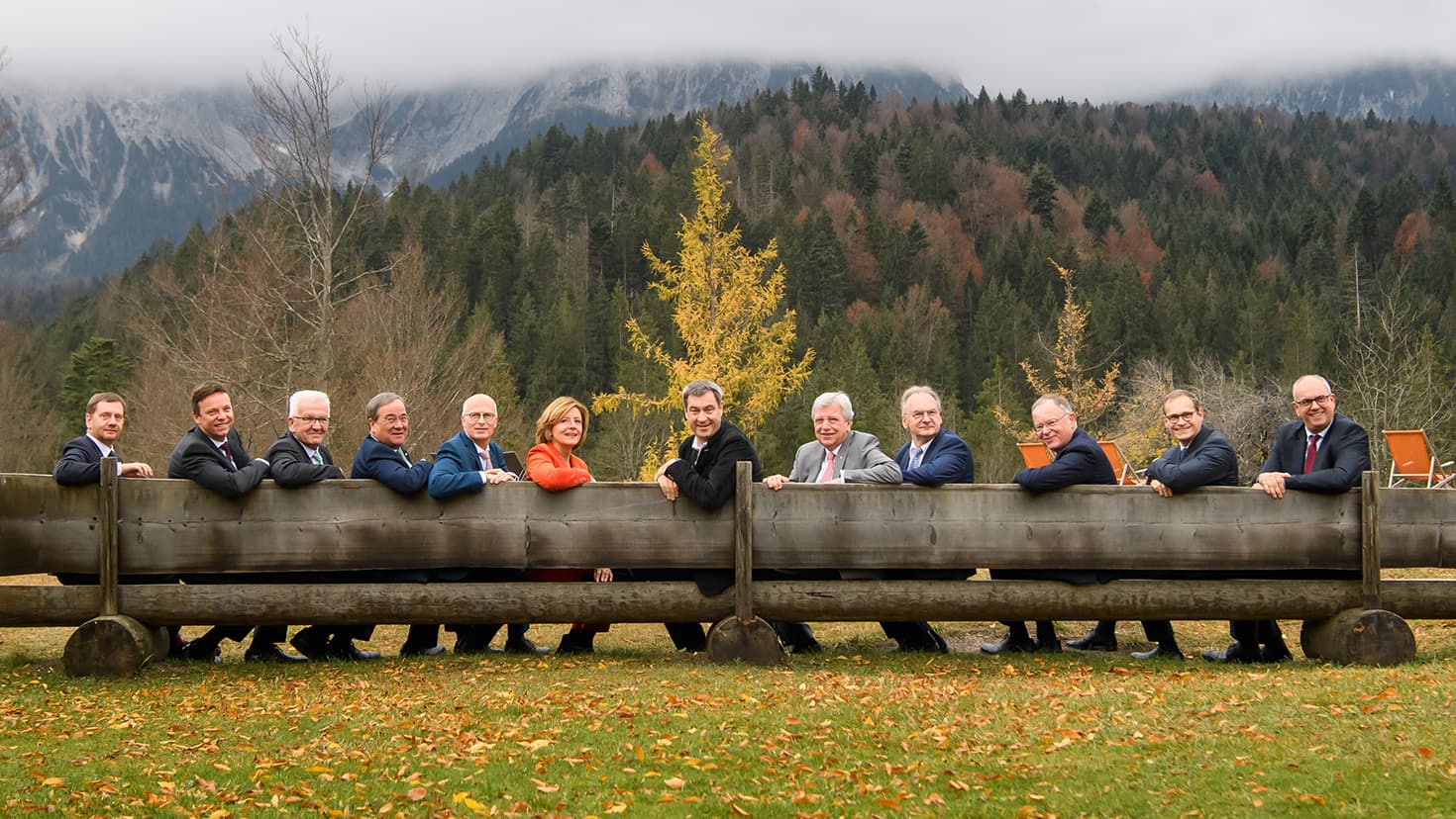 Die Regierungschefinnen und Regierungschefs der Länder sitzen nach der Ministerpräsidentenkonferenz auf Schloss Elmau auf einer Bank.