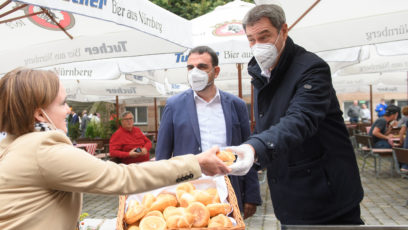 Corona-Impfaktion in Nürnberg: Gesundheitsminister Klaus Holetschek, MdL (Mitte), und Ministerpräsident Dr. Markus Söder, MdL (rechts), verteilen die „Drei im Weggla“ an Geimpfte.