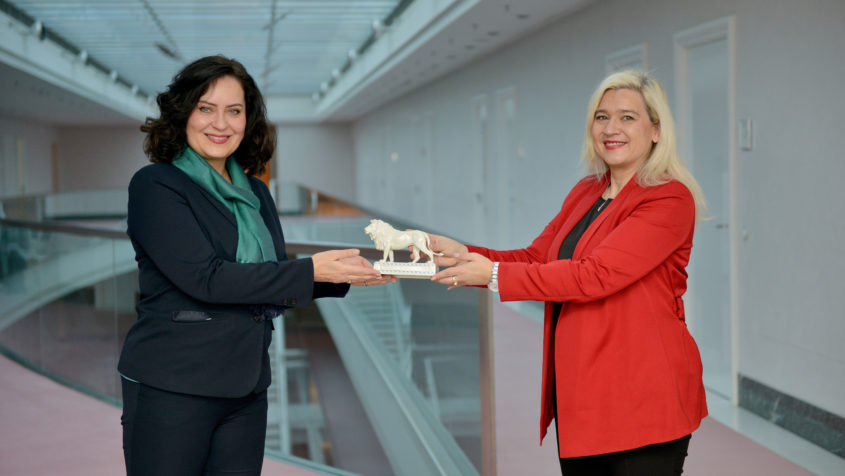 Europaministerin Melanie Huml, MdL (rechts), überreicht der Generalkonsulin der Tschechischen Republik Kristina Larischová (links) einen Bayerischen Löwen als Abschiedsgeschenk.