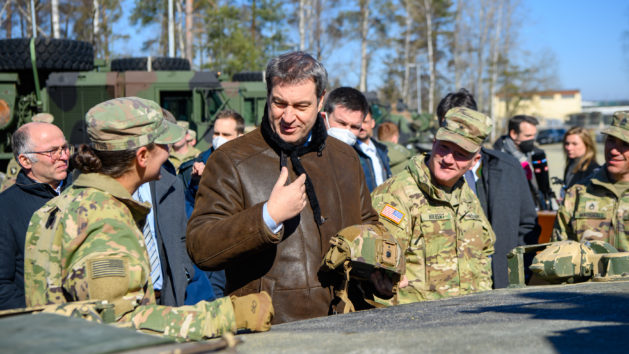 Ministerpräsident Dr. Markus Söder, MdL (Mitte), tauscht sich mit Soldatinnen und Soldaten bei einer Artillerieübung der US-Army aus.