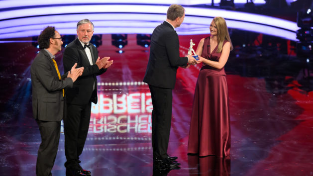 Laudatorin Digitalministerin Judith Gerlach, MdL (rechts), verleiht den Produzentpreis an Fritjof Hohagen (2.v.r.) mit Stefan Sarazin und Peter Keller für "Nicht ganz Koscher – eine göttliche Komödie".