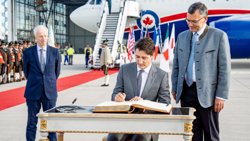 Premierminister Justin Trudeau trägt sich in das Gästebuch ein.