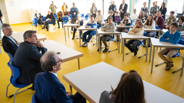 Treffen mit Brückenklassen am Staatliches Gymnasium München/Moosach: Kultusminister Prof. Dr. Michael Piazolo, MdL (links), und Ministerpräsident Dr. Markus Söder, MdL (2. von links), im Gespräch mit geflohenen Kindern und Jugendlichen aus der Ukraine.