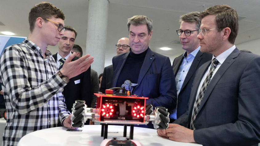 Ministerpräsident Dr. Markus Söder, MdL (Mitte), Wissenschaftsminister Markus Blume, MdL (2. von rechts), und Nürnbergs Oberbürgermeister Marcus König (rechts) im Gespräch mit einem Studenten.