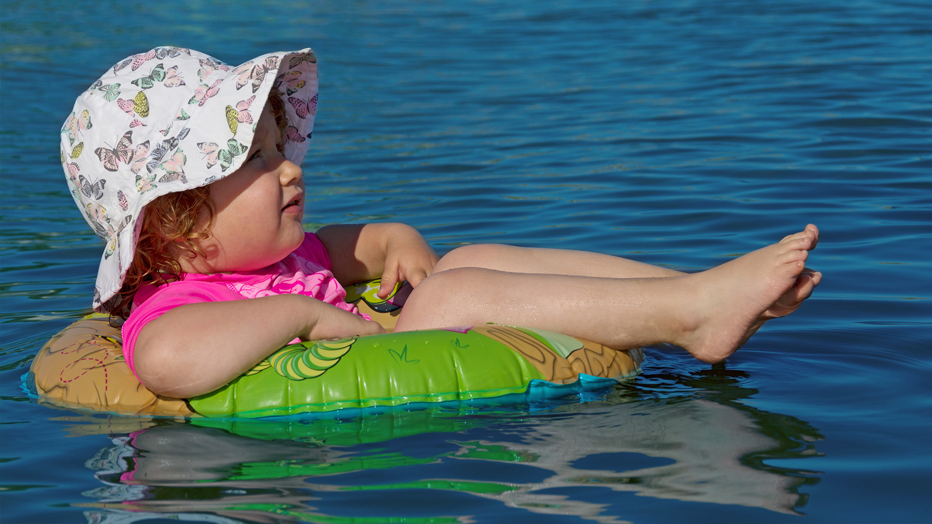 Kleinkind schwimmt auf Schwimmring im Wasser. © bluedesign - stock.adobe.com