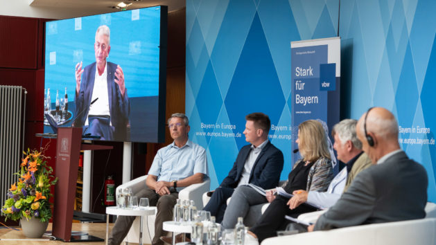 Die Teilnehmerinnen und Teilnehmer der Podiumsdiskussion (v.l.n.r.): Virtuell zugeschaltet der Hauptgeschäftsführer der vbw, Bertram Brossardt und vor Ort auf dem Podium Prof. Dr. Hubert Röder, Sprecher der Cluster-Initiative Forst und Holz in Bayern GmbH und Professor für Nachhaltige Betriebswirtschaft für Biotechnologie und Nachhaltigkeit in Straubing, Matthias Held, Director Public Affairs Germany bei UPM, die Moderatorin Christine Völzow, Geschäftsführerin und Leiterin der Abteilung Wirtschaftspolitik bei vbw – Vereinigung der Bayerischen Wirtschaft e.V., Ulrike Müller, MdEP (Renew) und Martin Häusling, MdEP (Die Grünen/EFA) sowie Humberto Delgado Rosa, Direktor des Referats für Biodiversität der Generaldirektion Umwelt der Europäischen Kommission. © Zacarias Garcia