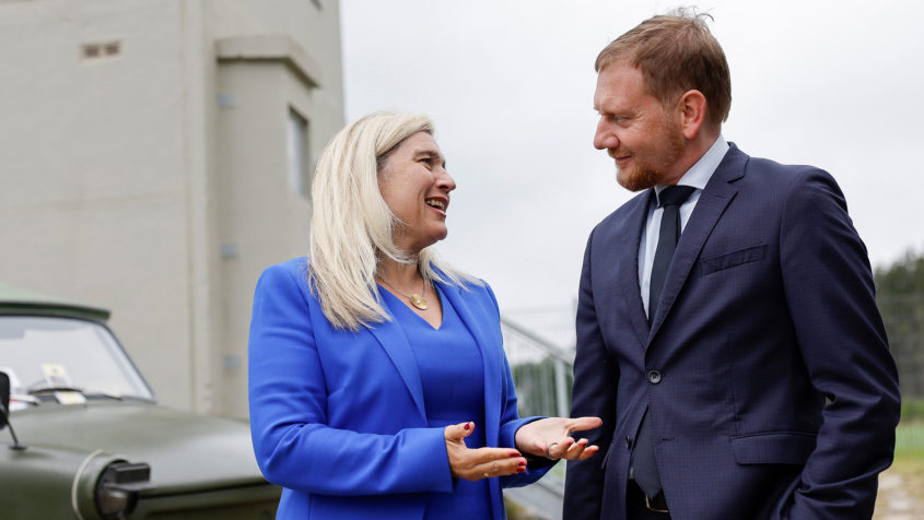 Europaministerin Melanie Huml (links) im Gespräch mit Sachsens Ministerpräsident Michael Kretschmer (rechts) vor der sanierten Gedenkstätte „Grenzturm Heinersgrün“.