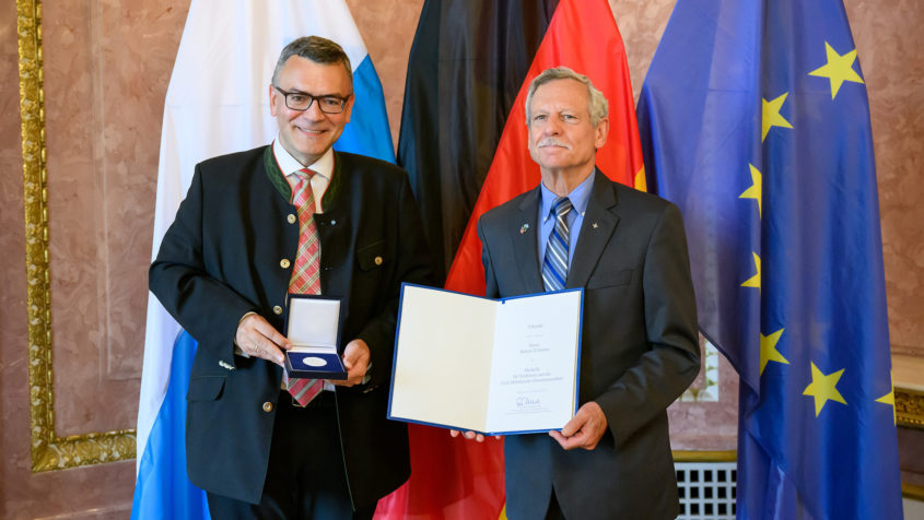 230918_Verleihung der Medaille für Verdienste um die Zivil-Militärische Zusammenarbeit_FR_2 Staatsminister Dr. Florian Herrmann und der Verbindungsoffizier ...