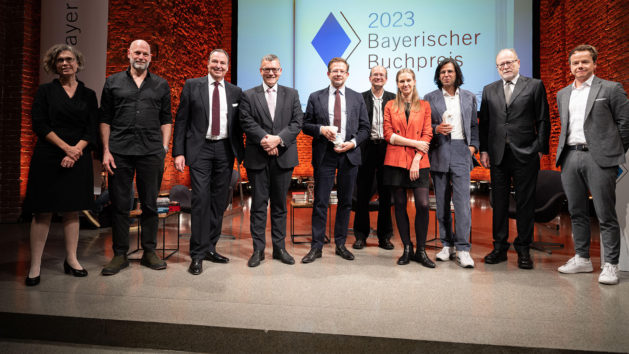 Gruppenbild mit Staatsminister Dr. Florian Herrmann (4. von links) und den Preisträgerinnen und Preisträgern bei der Verleihung des Bayerischen Buchpreises 2023 in der Allerheiligen-Hofkirche in München.