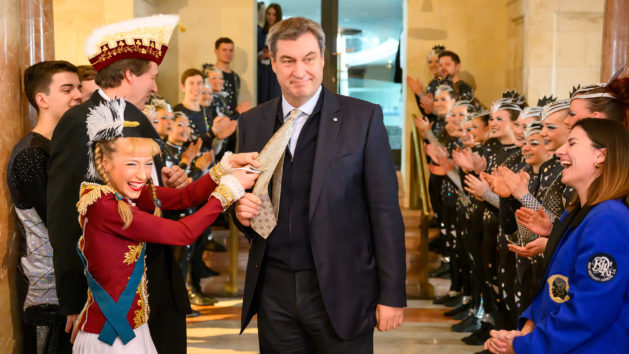 Das "Tanzmariechen" Melina Meißner schneidet Ministerpräsident Dr. Markus Söder die Krawatte ab.