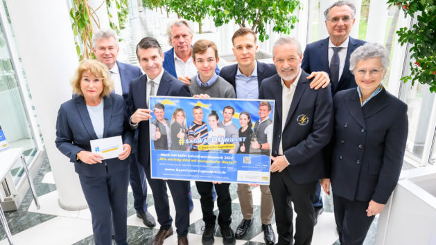 Gruppenbild zum Start des 4. Schreibwettbewerbs des Bayerischen Jugendpreises unter anderem mit Europaminister Eric Beißwenger (3. von links), dem Profiboxer und Europameister Alem Begić (4. von links) sowie mit Vertretern der Initiative Werterhalt & Weitergabe e. V.