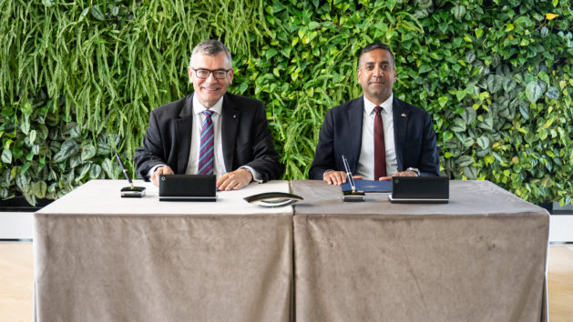 Staatsminister Dr. Florian Herrmann (links) und der Chief Revenue Officer von Axiom Space Inc., Tejpaul Bhatia (rechts) unterzeichnen eine Absichtserklärung zur Zusammenarbeit bei Raumfahrtaktivitäten im erdnahen Orbit.