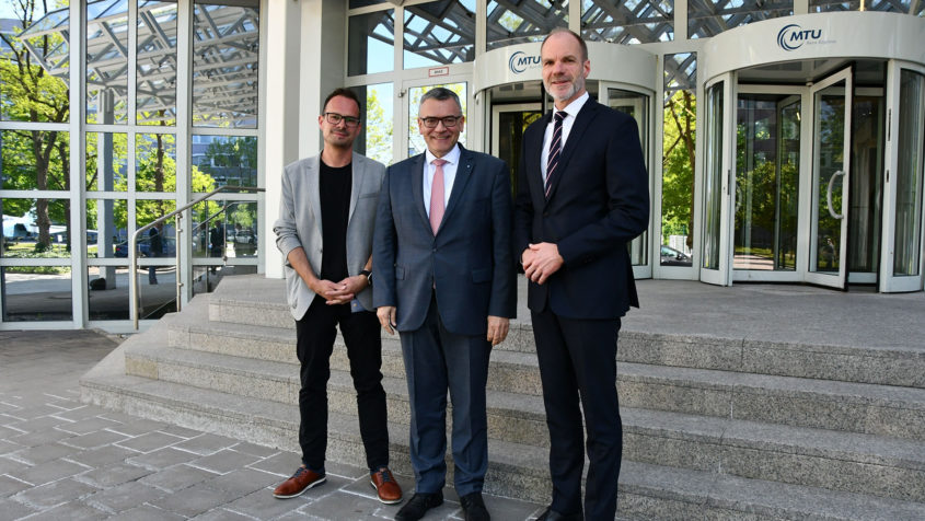 Der CEO der MTU Aero Engines AG, Lars Wagner (rechts), und der Betriebsratsvorsitzende der MTU Aero Engines AG, Tom Stocker (links), empfangen Staatsminister Dr. Florian Herrmann (Mitte). © MTU Aero Engines AG
