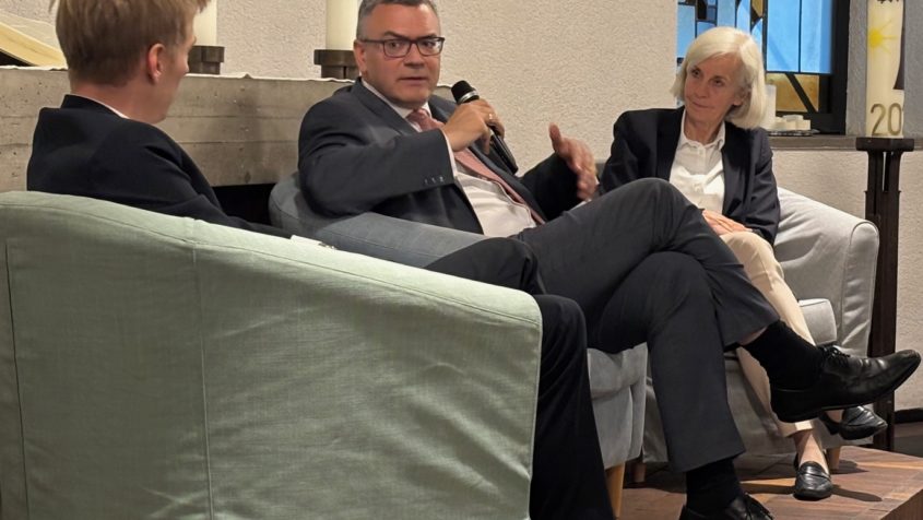 Der Zweite Bürgermeister der Stadt München, Dominik Krause (links), und Staatsminister Dr. Florian Herrmann (Mitte) diskutieren zum Thema „Polarisierung in der Gesellschaft – Wohin entwickelt sich unsere Demokratie?“. Moderiert wird das Gespräch von der Direktorin der Akademie für Politische Bildung, Prof. Dr. Ursula Münch (rechts).