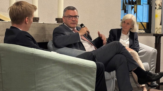 Der Zweite Bürgermeister der Stadt München, Dominik Krause (links), und Staatsminister Dr. Florian Herrmann (Mitte) diskutieren zum Thema „Polarisierung in der Gesellschaft – Wohin entwickelt sich unsere Demokratie?“. Moderiert wird das Gespräch von der Direktorin der Akademie für Politische Bildung, Prof. Dr. Ursula Münch (rechts).