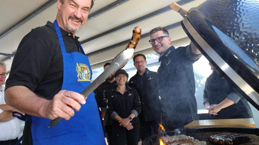Bei seinem Besuch bei der Metzgerei Freyberger in Nürnberg grillt Ministerpräsident Dr. Markus Söder die fränkische Weltmeisterbratwurst "König Ludwigs Apfel-Zwiebel-Bratwurst".