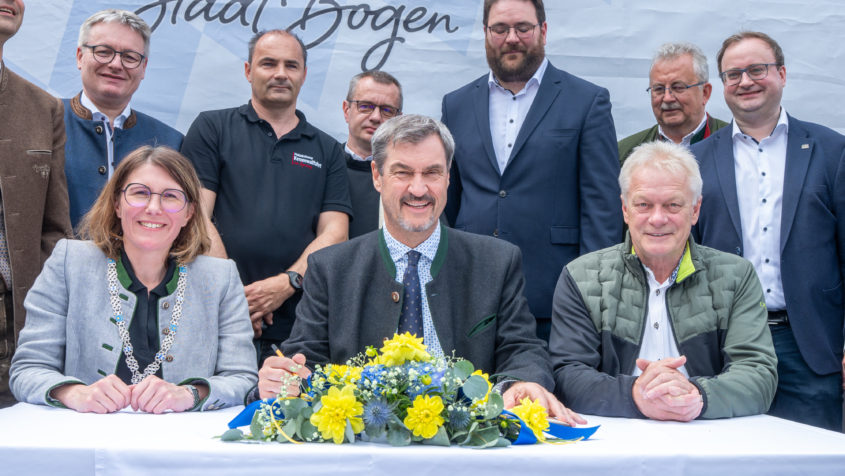 Bei seinem Besuch trägt sich Ministerpräsident Dr. Markus Söder (Mitte) im Beisein von der Ersten Bürgermeisterin der Stadt Bogen, Andrea Probst (links), und Bundeslandwirtschaftsminister Alois Rainer (rechts) in das Goldene Buch der Stadt Bogen ein.