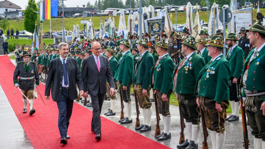 An der Talstation "Seilbahn Zugspitze" schreiten Ministerpräsident Dr. Markus Söder und Bundeskanzler Friedrich Merz die Front der Großen Ehrenkompanie der Bayerischen Gebirgsschützen ab.