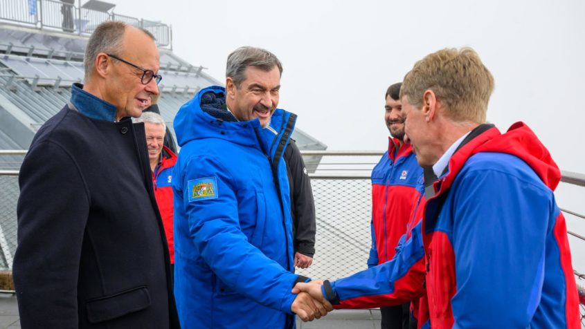 Auf der Zugspitze treffen Bundeskanzler Friedrich Merz und Ministerpräsident Dr. Markus Söder vier ehrenamtliche Rettungskräfte und Luftretter der Bergwacht Grainau.