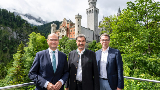 Finanz- und Heimatminister Albert Füracker, Ministerpräsident Dr. Markus Söder sowie Wissenschaft- und Kunstminister Markus Blume auf der Aussichtsplattform am Zimmermannsplatz mit Schloss Neuschwanstein im Hintergrund.