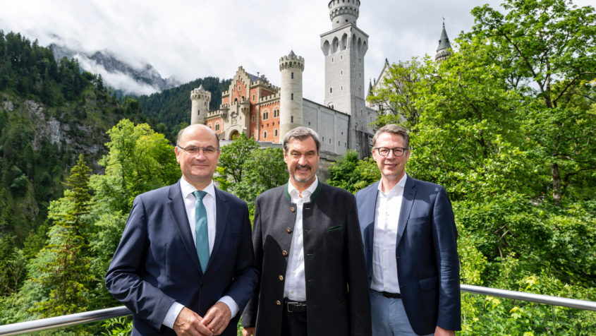 Finanz- und Heimatminister Albert Füracker, Ministerpräsident Dr. Markus Söder sowie Wissenschaft- und Kunstminister Markus Blume auf der Aussichtsplattform am Zimmermannsplatz mit Schloss Neuschwanstein im Hintergrund.