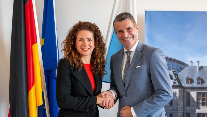 Europaminister Eric Beißwenger (rechts) begrüßt die Präsidentin des EU-Ausschusses der Regionen, Kata Tüttö (links), zu einem europapolitischen Austausch in der Bayerischen Staatskanzlei.