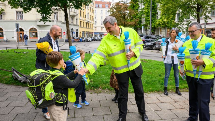 Ministerpräsident Dr. Markus Söder und Staatskanzleiminister Dr. Florian Herrmann überreichen Erstklässler eine Schultüte zum Schulstart in Bayern.